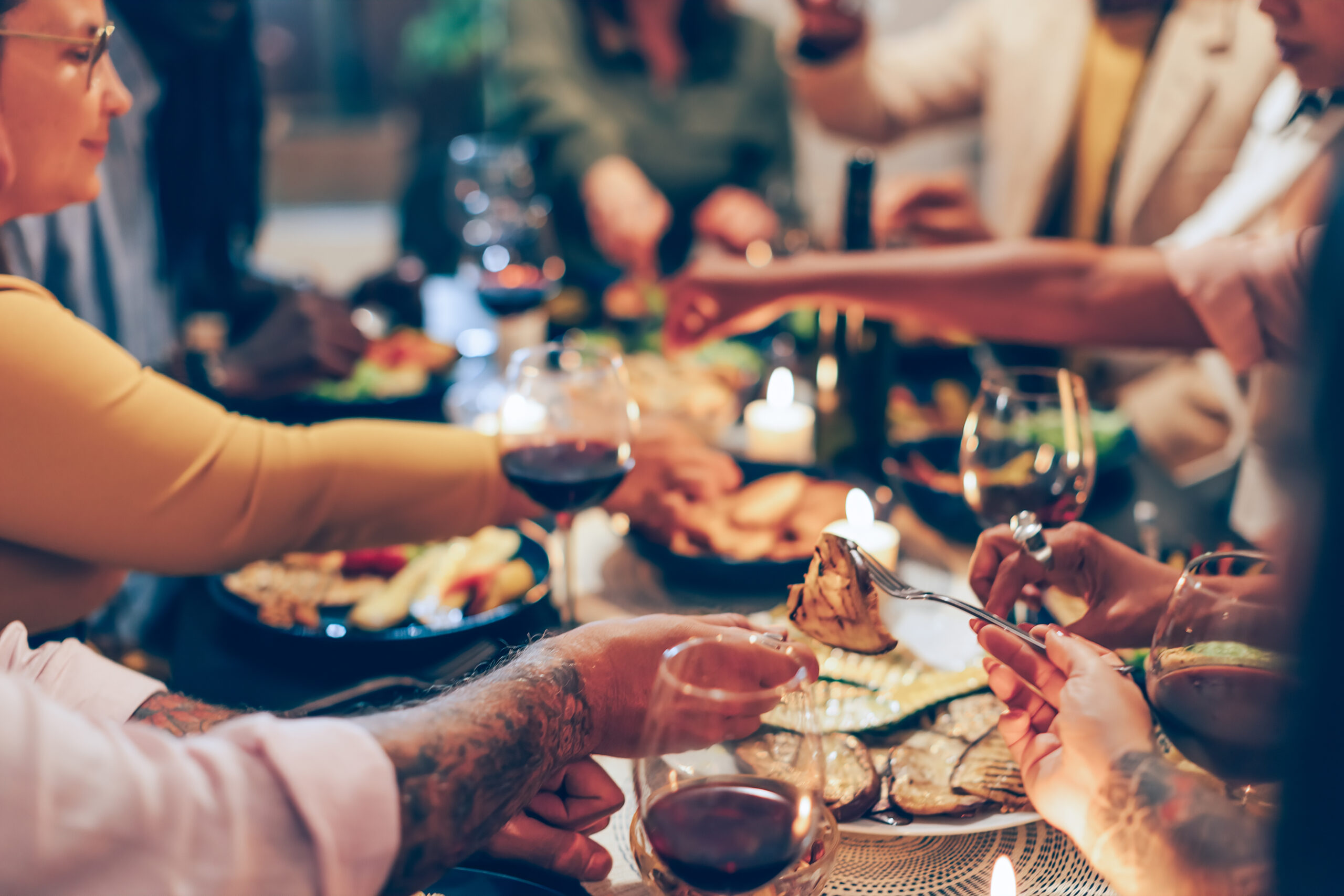 family sitting at the table - family having dinner together - focus in the foreground