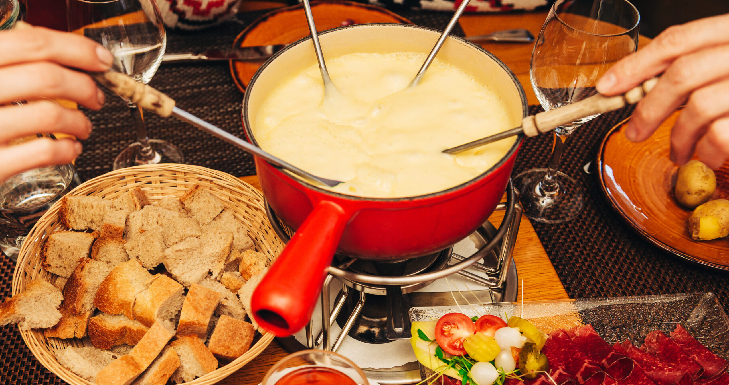 Friends eating cheese fondue in a cozy traditional swiss restaurant