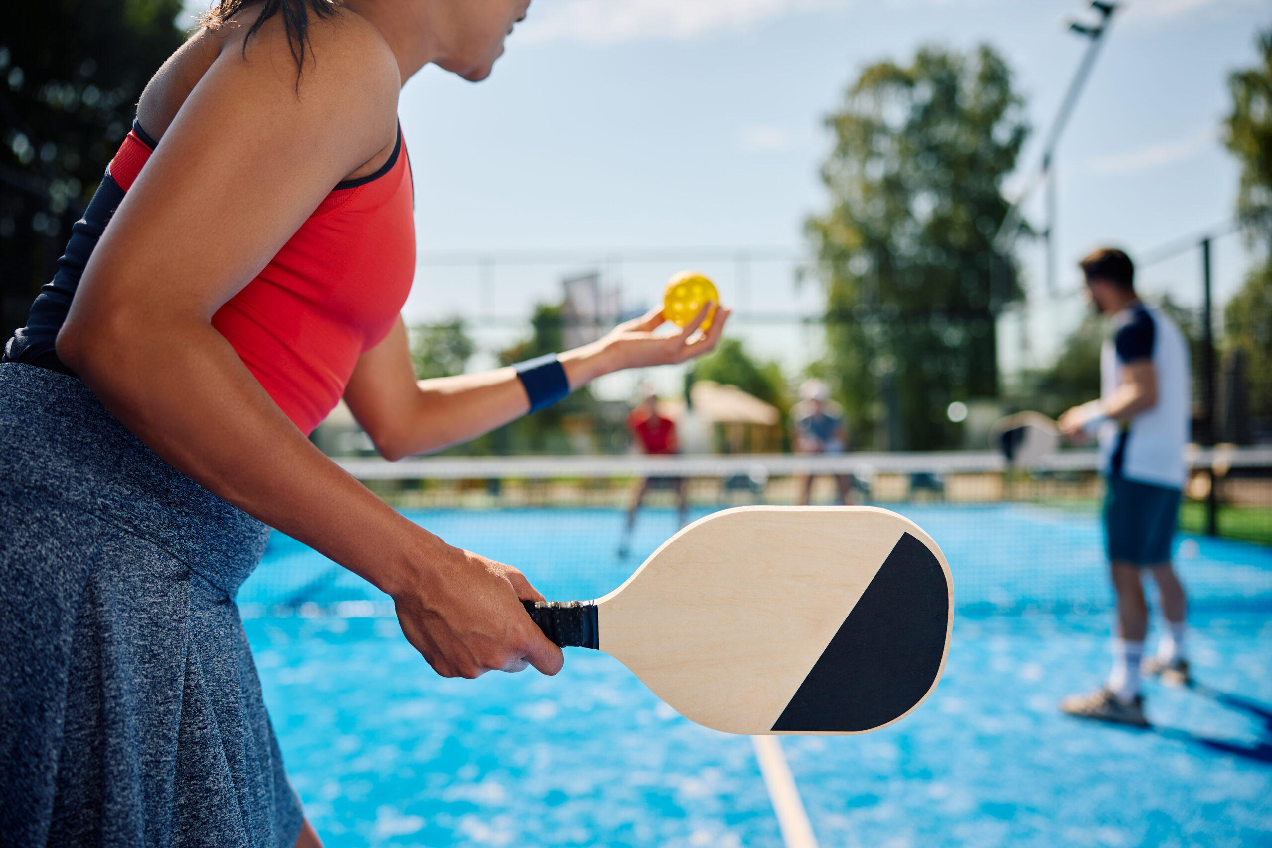 Female pickleball player serving the ball during the match on outdoor court in Park City hosted by Luxe Haus