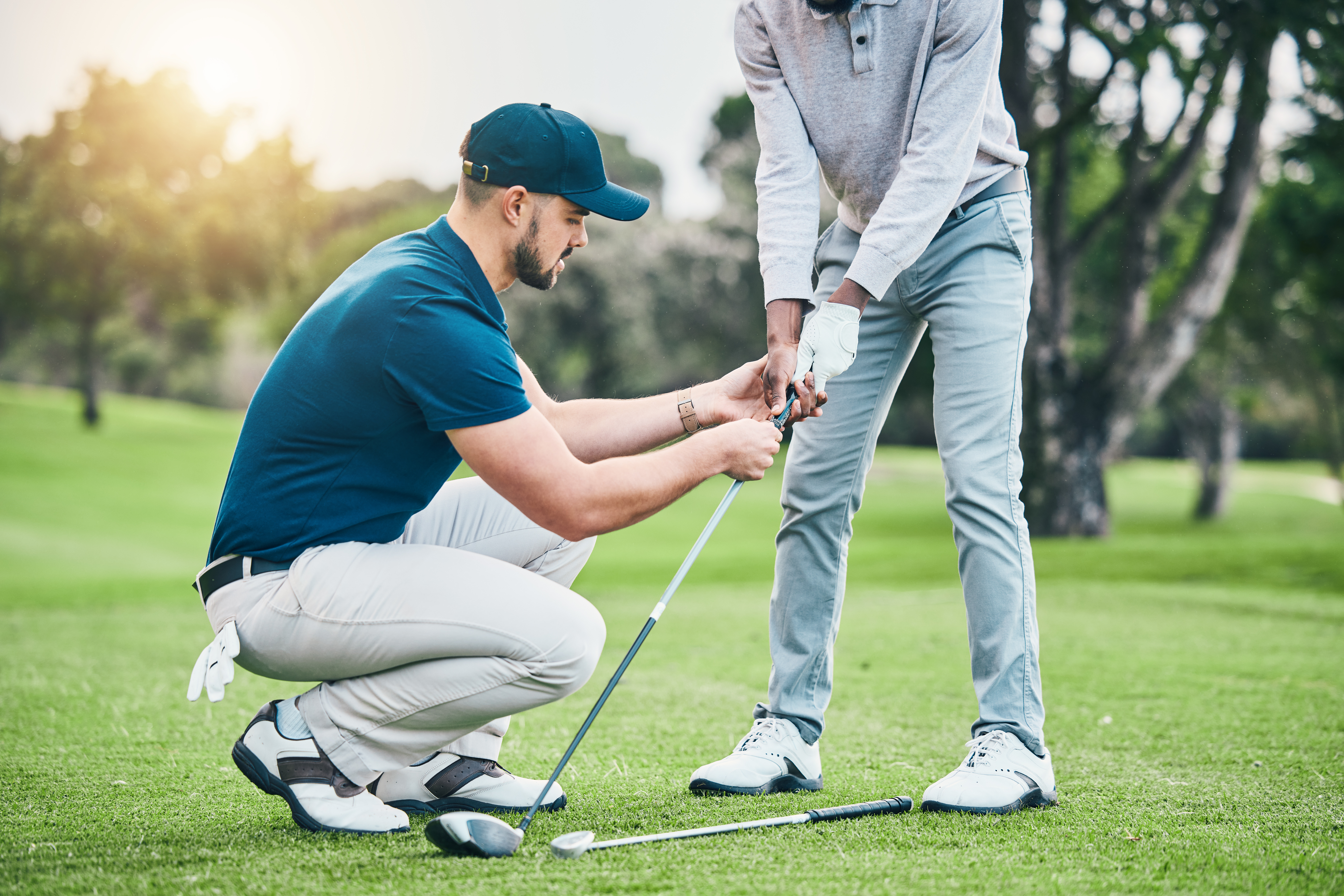 Golf lessons in Park City, teaching and sports coach help man with swing, putt and stroke outdoor. Lens flare, green course and club support of a athlete ready for exercise, fitness and training for a game