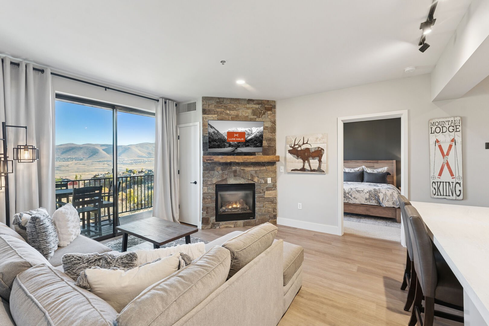 The living room of The Mason 3026 with a view into the bedroom and a view of the mountains out of the large windows