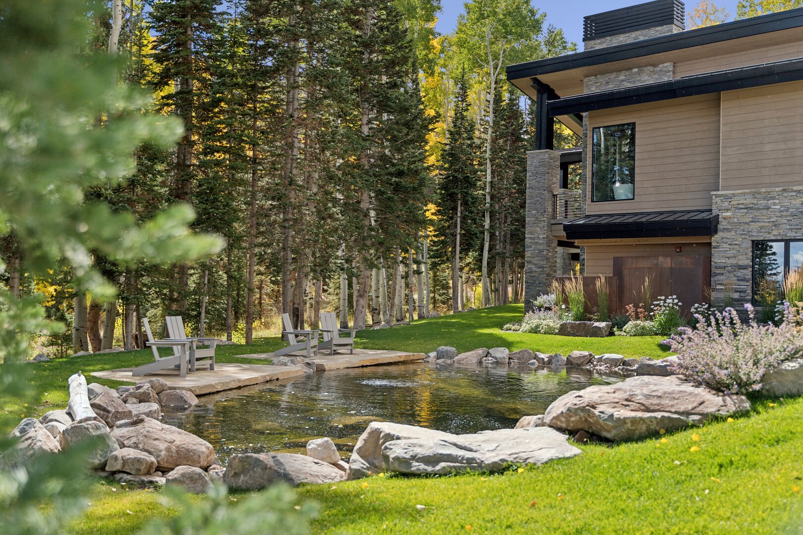 The lush pond area with lounge chairs and mountain views The lush pond area with lounge chairs and mountain views