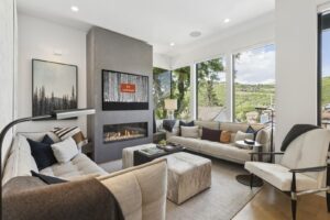 a chic living room area with a view of main street in park city, fire is burning and the screen saver has the Luxe Haus logo on the TV