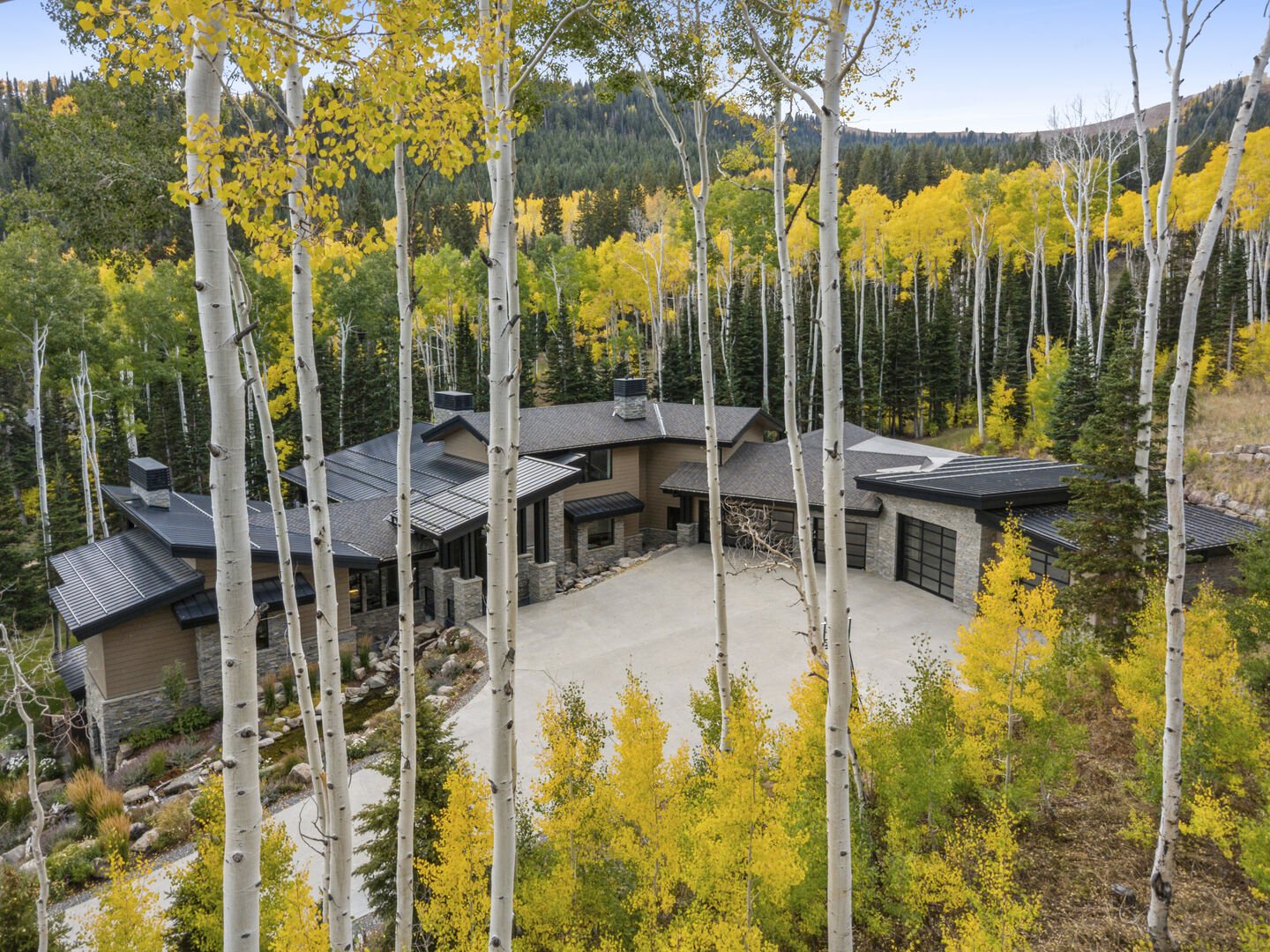 All Inn at The Colony surrounded by aspen in autumn with bright fall color and a view of the mountains in the background