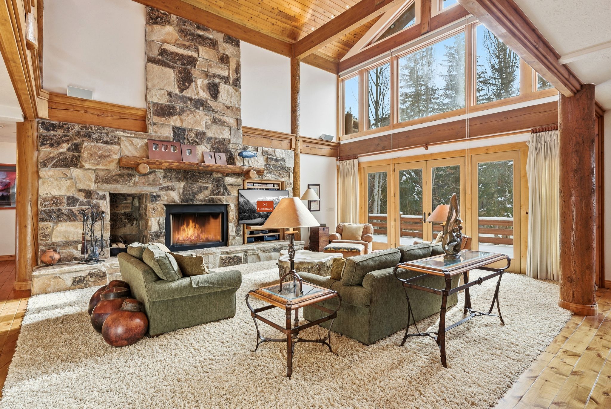 the cozy log cabin inspired interior of Sun Ridge with large fireplace and wood beam accents