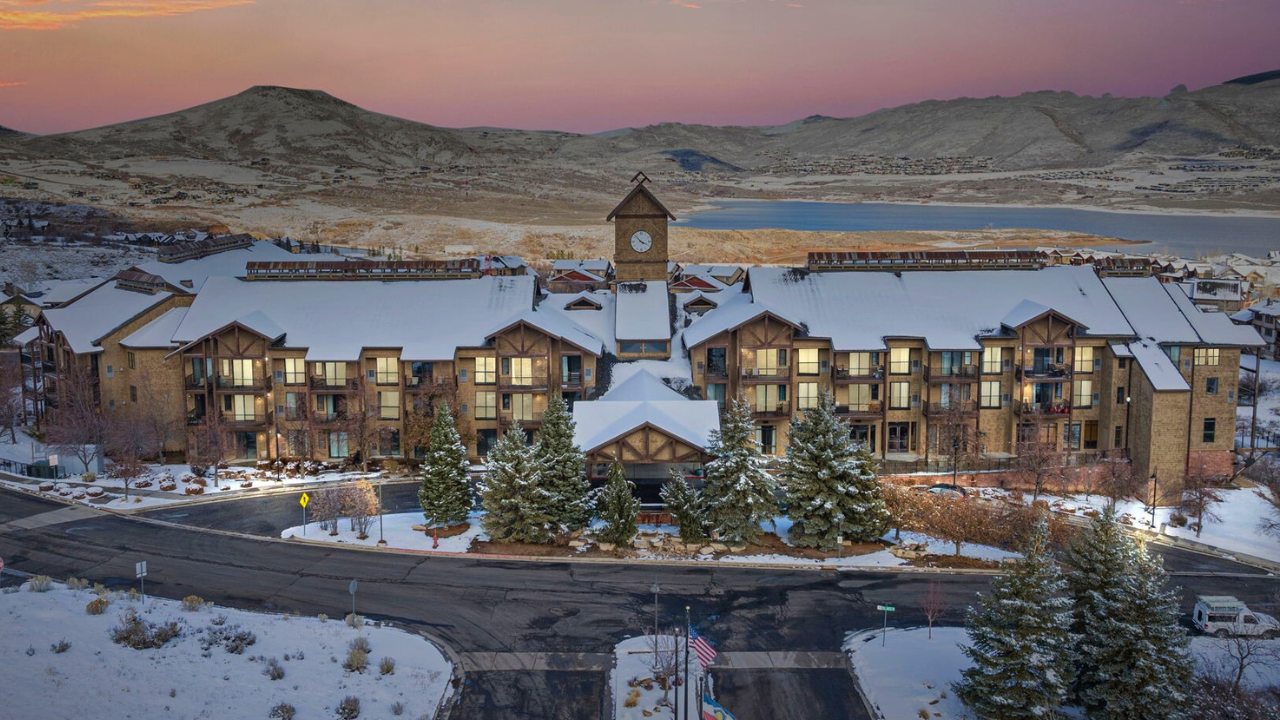 The Mason luxury condo complex in Deer Valley east at sunset. you can see the lake behind the building and the mountains in the distance