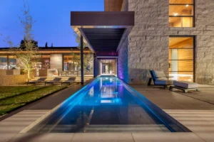 an indoor/outdoor swimming pool glowing at twilight