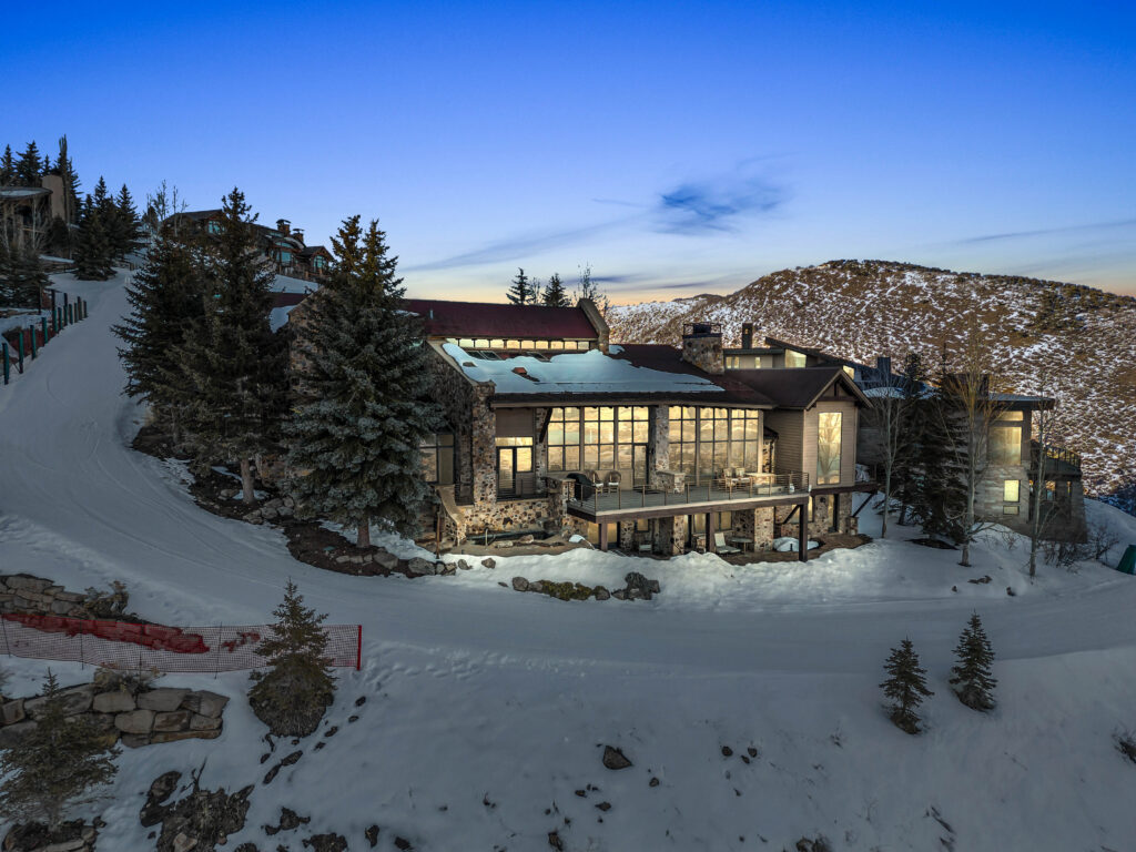 snow pine at deer valley at sunset with ski slopes visible in front of the home