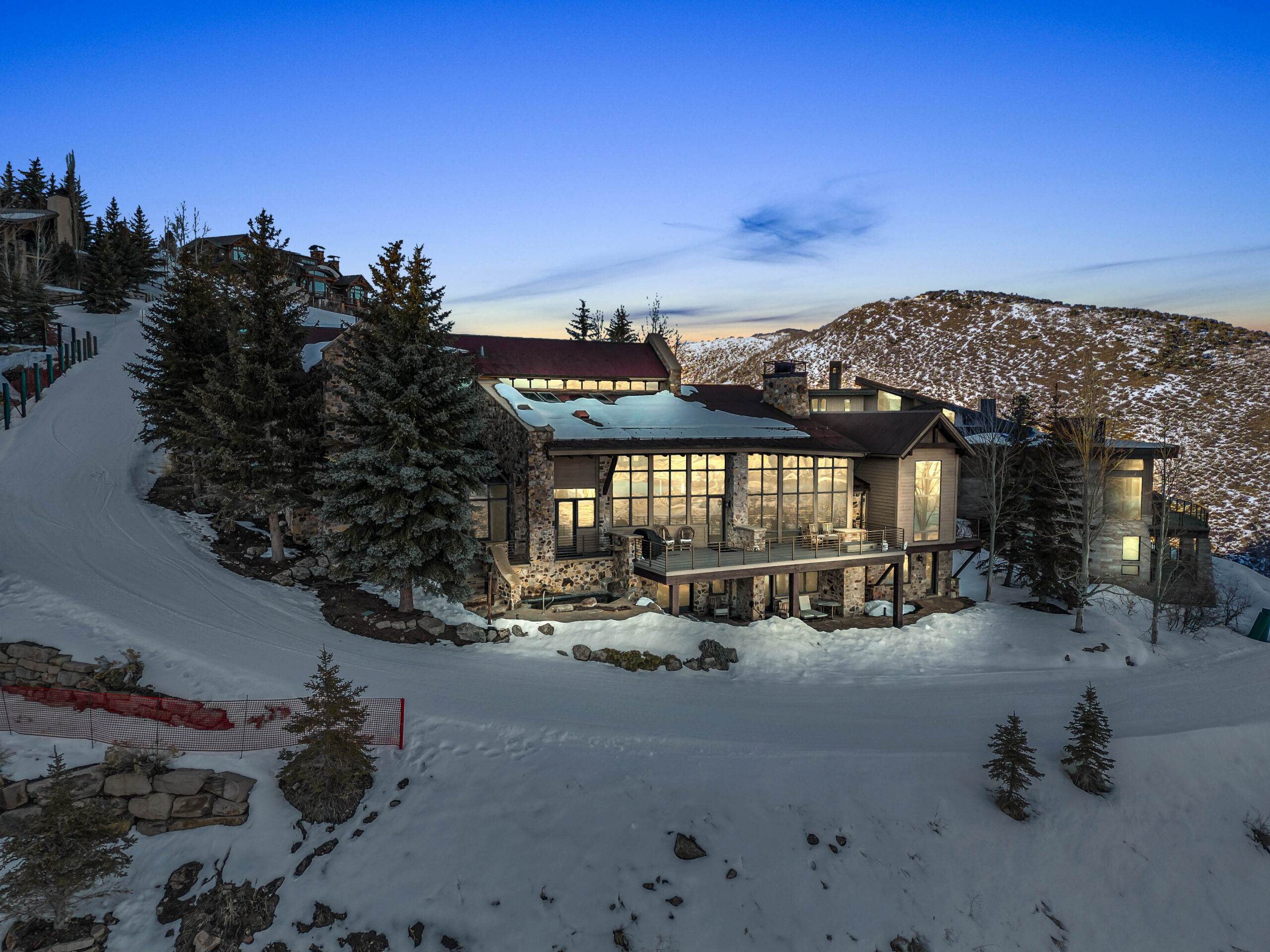 snow pine at deer valley at sunset with ski slopes visible in front of the home