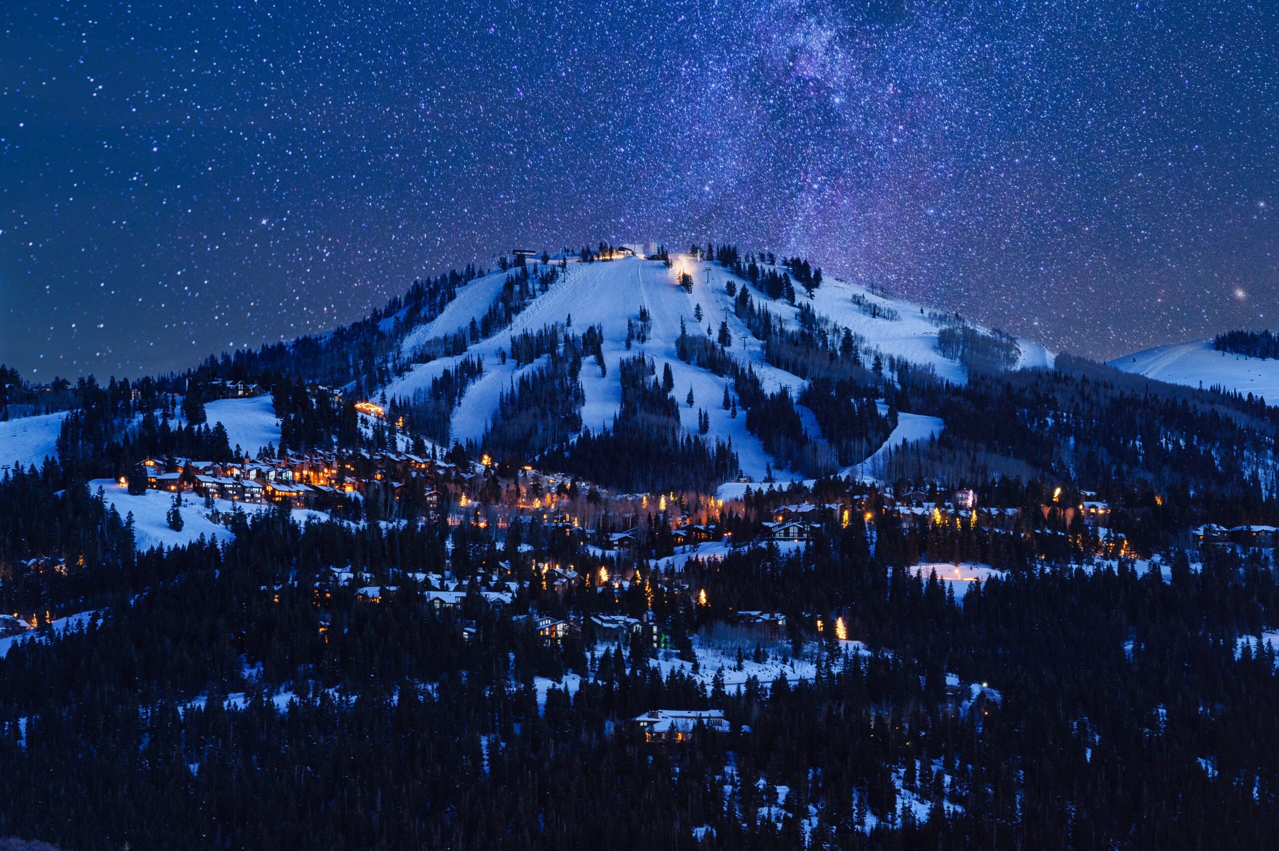 The mountains and ski slopes of park city utah at night with the milky way visible overhead